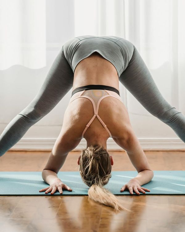 Woman in a calm yoga pose in a dark room with emerald light.
